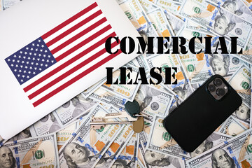 Comercial lease concept. USA flag, dollar money with keys, laptop and phone background.