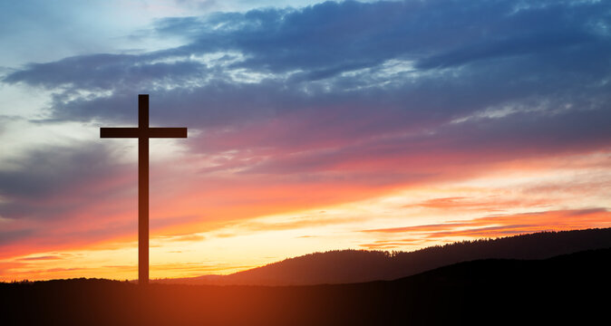 Christian cross on hill outdoors at sunrise. Resurrection of Jesus.
