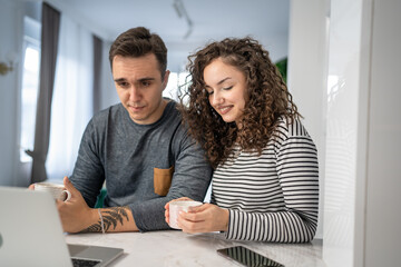 happy couple using laptop computer with cup of coffee morning routine