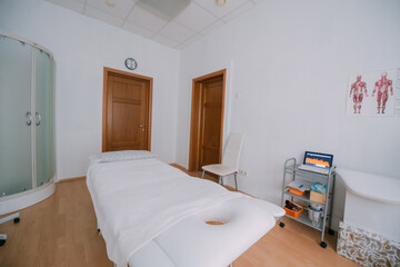 Fototapeta na wymiar The interior of the massage and cometology salon, massage table. Nobody.