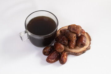 Cup of black tea served with dates fruit. ramadan. muslim. halal. takjil. isolated on white background