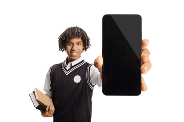 African american male student in a uniform holding books and showing a smartphone