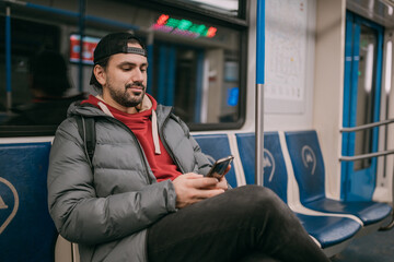 Fototapeta premium A young man rides standing in a modern subway car.