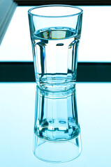 Reflection of a glass of spring water in the mirror