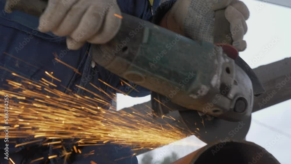 Poster carpenter cutting pipe with saw with sparks. clip. close-up of stream of sparks from circular saw. c