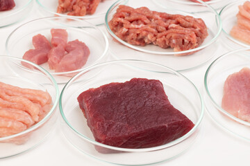 Checking meat quality in a laboratory. Chicken, beef and pork samples in petri dishes, top view. Food quality concept.