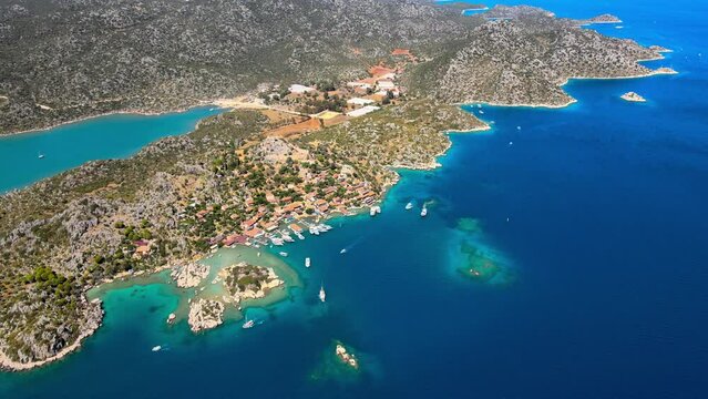 Drone video featuring Simena Castle (Kalek&ouml;y), beach, and yachts, revealing the coastal landscape and historic setting in Antalya, Turkey.