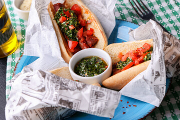 details of fresh made sausage and vegetable sandwich with chimichurri sauce