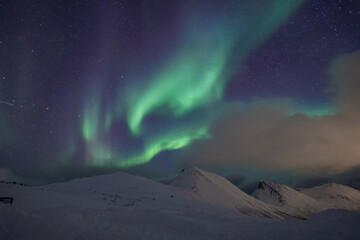 Fototapeta na wymiar snow covered mountains with Aurora Borealis