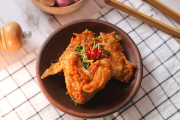 sayap mercon or spicy chicken wings serving on tray bamboo. tasty grilled chicken wings on a white dish, top view. sayap pedas.