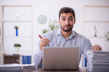 Young male employee and too much work in the office