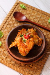 sayap mercon or spicy chicken wings serving on tray bamboo. tasty grilled chicken wings on a white dish, top view. sayap pedas.