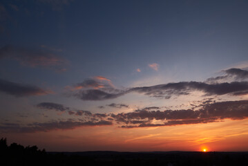 Naklejka na ściany i meble Sky with clouds, with the setting sun.
