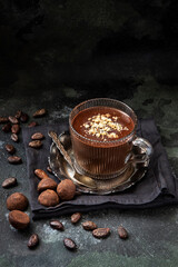 Thick spicy hot chocolate in  glas cup on   dark  background