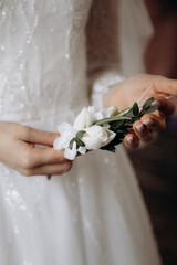 a young girl in a white wedding dress holds a bouquet of flowers and greenery with a ribbon in her hands