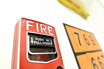 Red fire alarm button in the building. Push in pull down.
