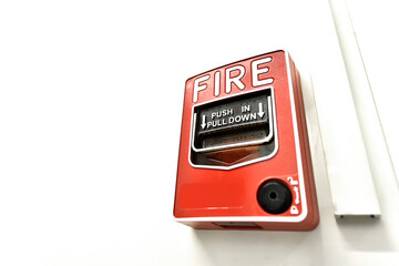 Red fire alarm button in the building. Push in pull down.