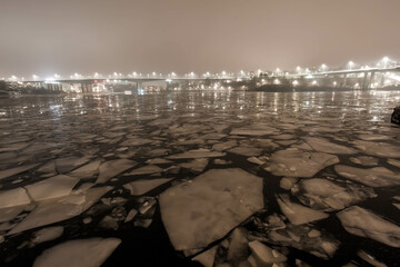 Fototapeta premium City lights over ice floes and water. Lake Mälaren in Sweden's capital Stockholm.