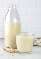 Bottle and glass of oat milk, oatmeal on a white background. copy space. The concept of alternative lactose-free dairy products.