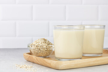 Two glasses of oat milk and oatmeal on a white background. copy space. The concept of alternative lactose-free dairy products.