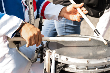 Hands of a person playing a snare with drumsticks.