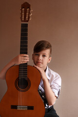 Fototapeta premium Young handsome guitar player, boy with guitar, children playing the guitar