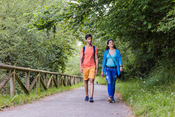 Fototapeta na wymiar Senda del oso, Teverga Asturias. mixed race travelers couple hiking ecotourism conservation path