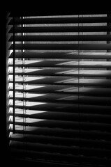 Window blinds partially open black and white film noir
