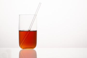 Red liquid in the glass with the glass straw.