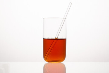 Red liquid in the glass with the glass straw.