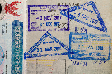 Inside page of a traveled Ukrainian passport with stamps from customs of Thailand. Border stamp in the passport when crossing the state border Thailand, closeup. Vacation and travel concept