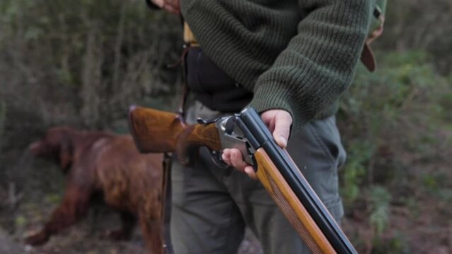 Close up view of a male hunter loading his gun while preparing to hunt.
