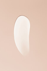 Close-up smear of cream texture on a beige background