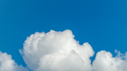 Naklejka na ściany i meble Fluffy white clouds and blue sky. A white fluffy cloud.
