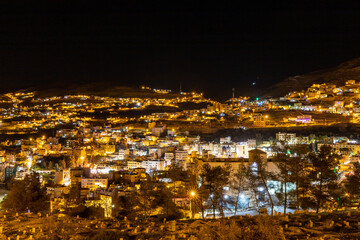 Naklejka premium Wadi Musa, Jordan A night view of the city of Petra in the hills.