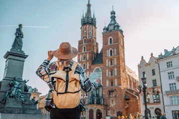 Foto op Canvas Back view of traveller woman walking on old Market Square in Krakow holding tourist map. Travel and active lifestyle concept. High quality photo © Shi 