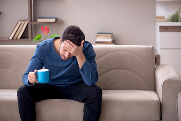 Young man drinking tea at home