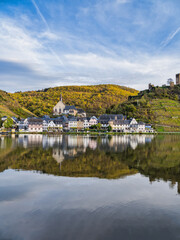 Fototapeta na wymiar Vertical shot of Beilstein village wiht clear reflection on Moselle river during autumn in Cochem-Zell district, Germany