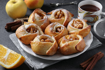 Buns with apples and cinnamon in the form of roses, sprinkled with powdered sugar, Closeup