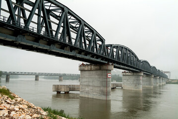 Iron bridge on concrete piers over the river