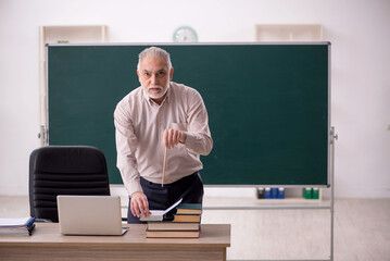 Old male teacher in the classroom