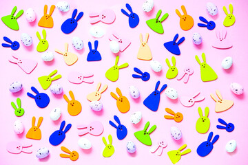 Fototapeta na wymiar Pattern of decorative rabbits and colored eggs on pink background. Happy Easter concept. Bold hues for seasonal projects. 