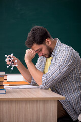 Obraz premium Young male physicist student in the classroom