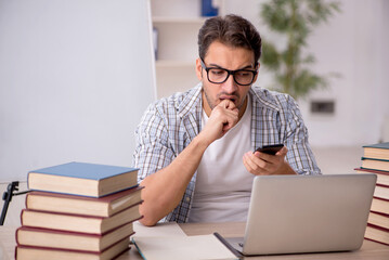 Young male student preparing for exams in the classroom