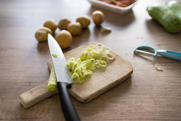 Fresh chopped leek on wooden cutting board.
