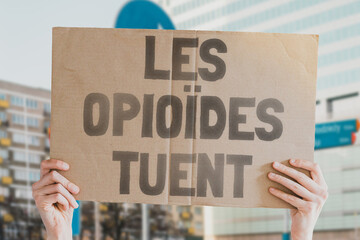 The phrase " Opioids kill " on a banner in men's hands is isolated on a white background. Medicine supply. Deadly drugs. Death. Treatment. Pharmacy. Dangerous. Drug addiction
