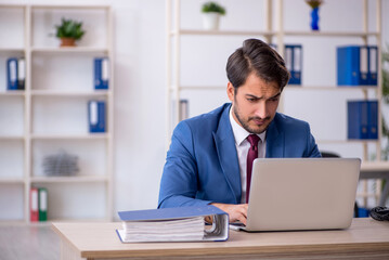 Young male employee and too much work in the office