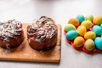 Easter Kraffin on a light background with colored, bright eggs. Cake with raisins, chocolate, nuts