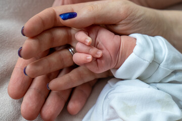 father and mother holding newborn baby's hand, close up family hold hands together, parent's love, tiny little fingers, happiness and care
