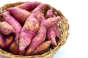 Sweet potato in bamboo basket on white background.